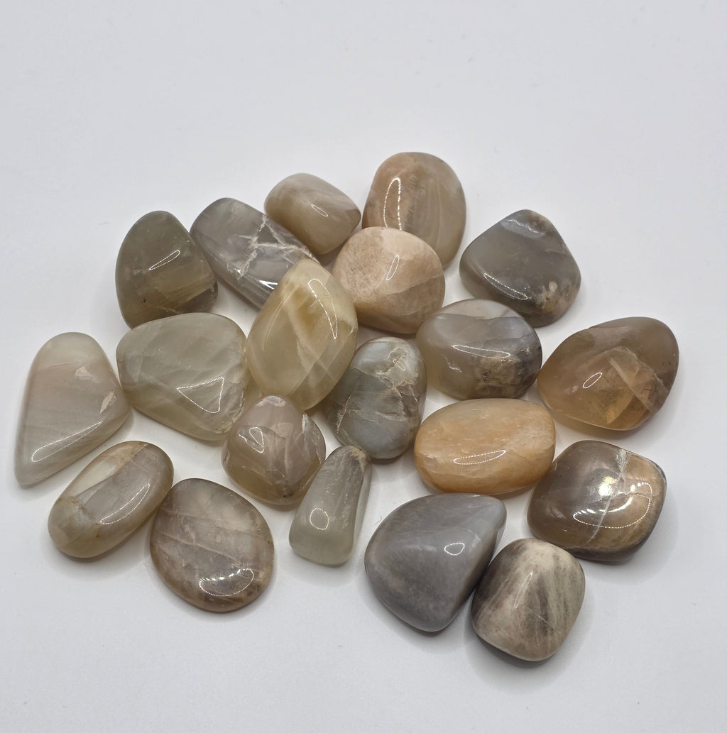 Group of pastel moonstone tumbled stones showing range of pastel colours – pink, peach, cream and white