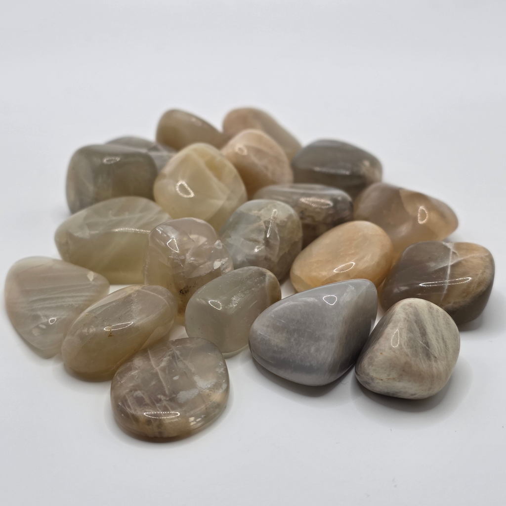 Group of pastel moonstone tumbled stones showing range of pastel colours – pink, peach, cream and white