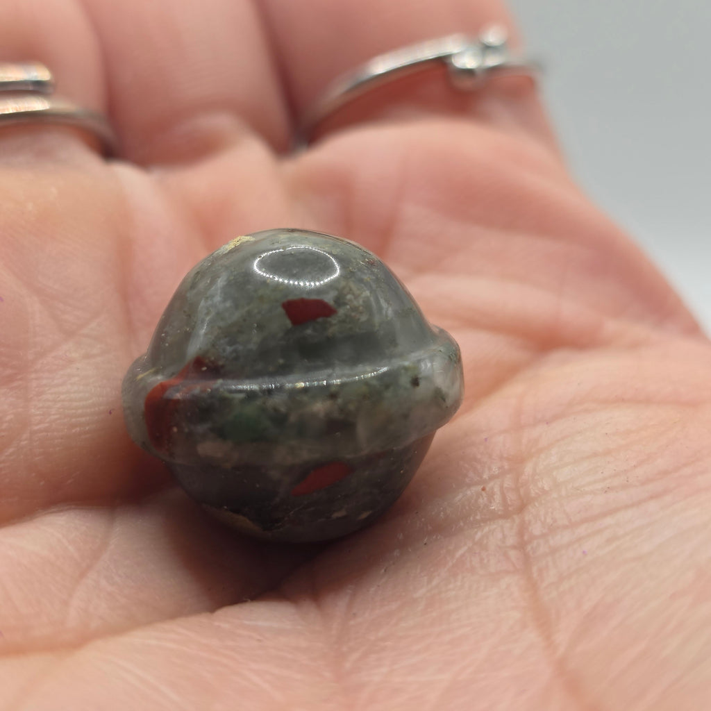 2cm crystal sphere held in a person's palm – tiny pocket planet natural stone ball