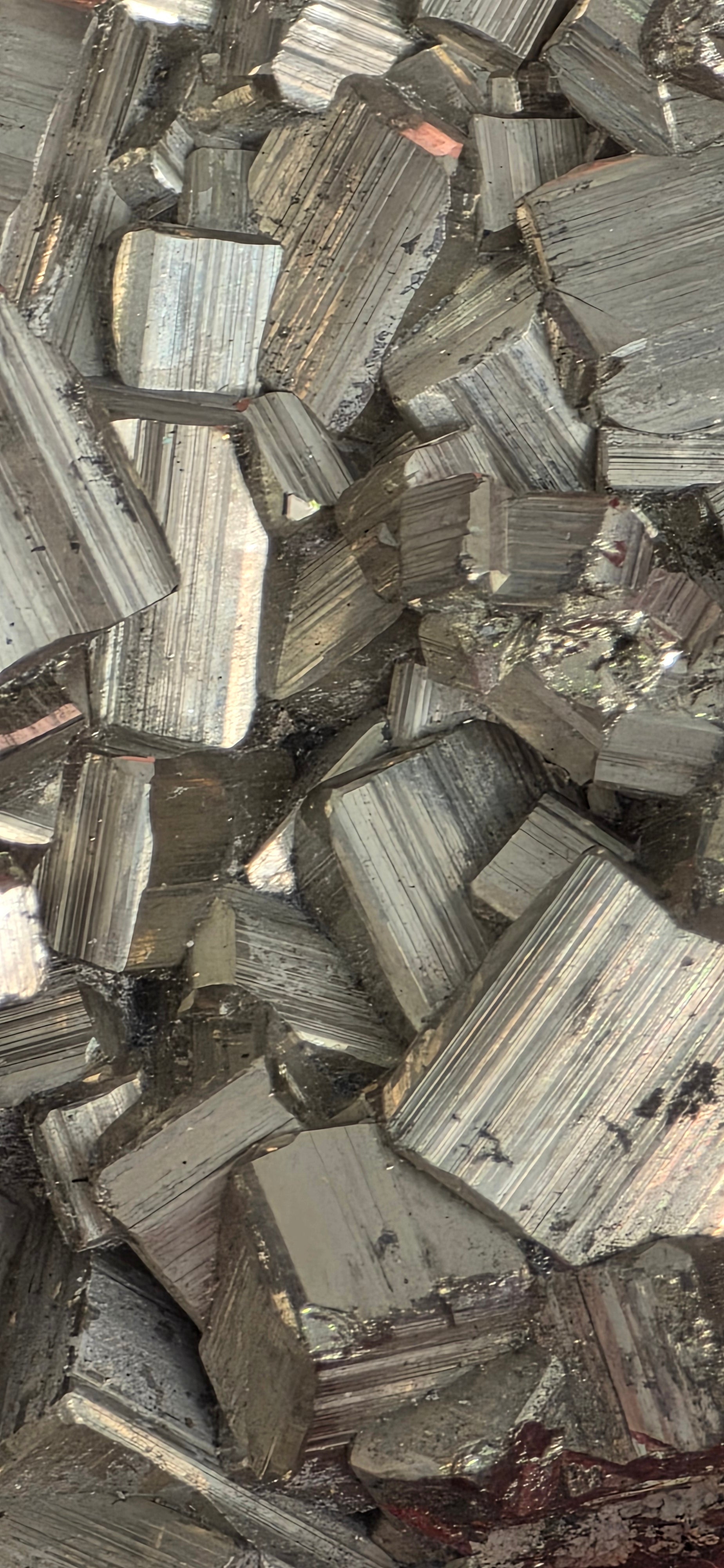 Close up of natural pyrite chispa cluster showing interlocking cubic crystal formations and metallic gold, silver colour