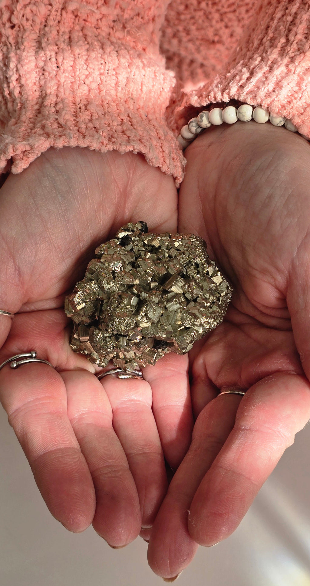 Large pyrite chispa cluster weighing 225 grams held in a person's palm showing substantial size and weight