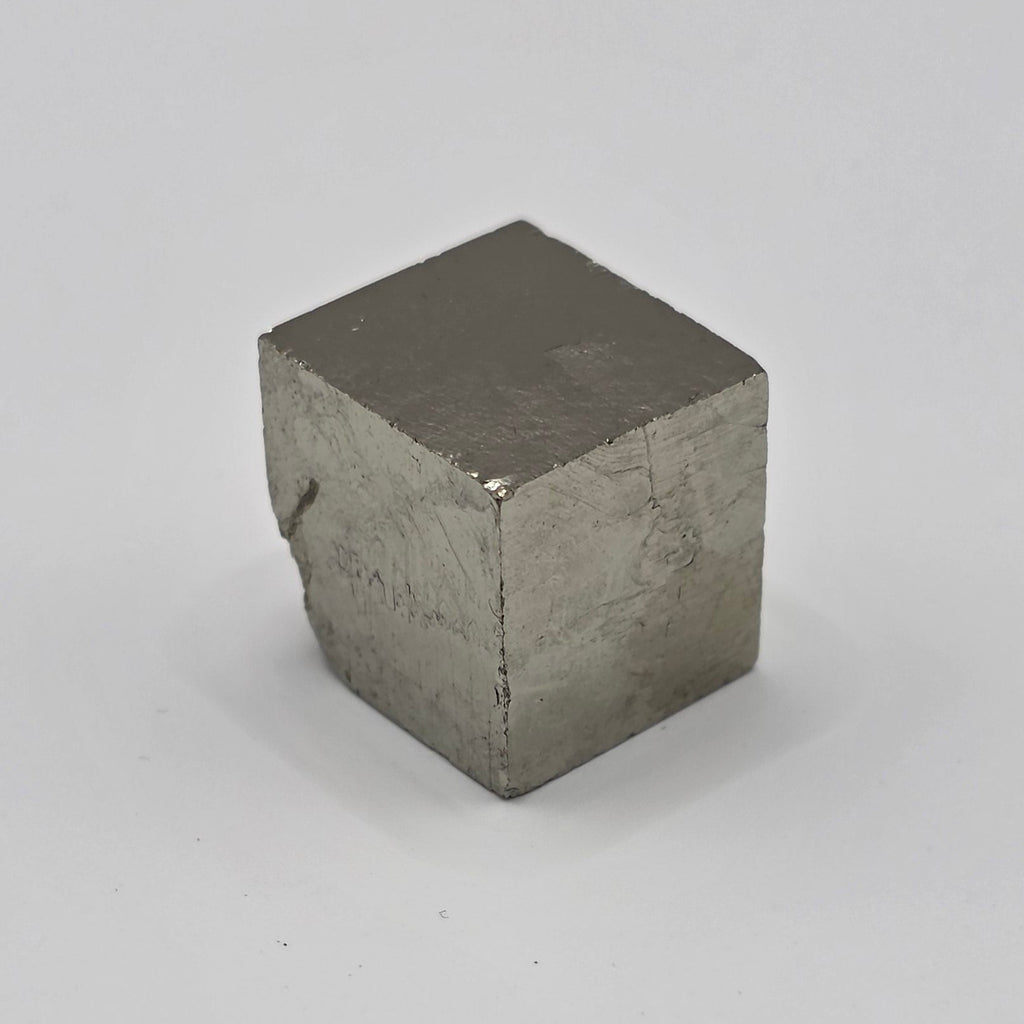 Natural pyrite cube 1cm on white background – metallic gold cubic crystal from Spain – fool's gold for wealth and abundance