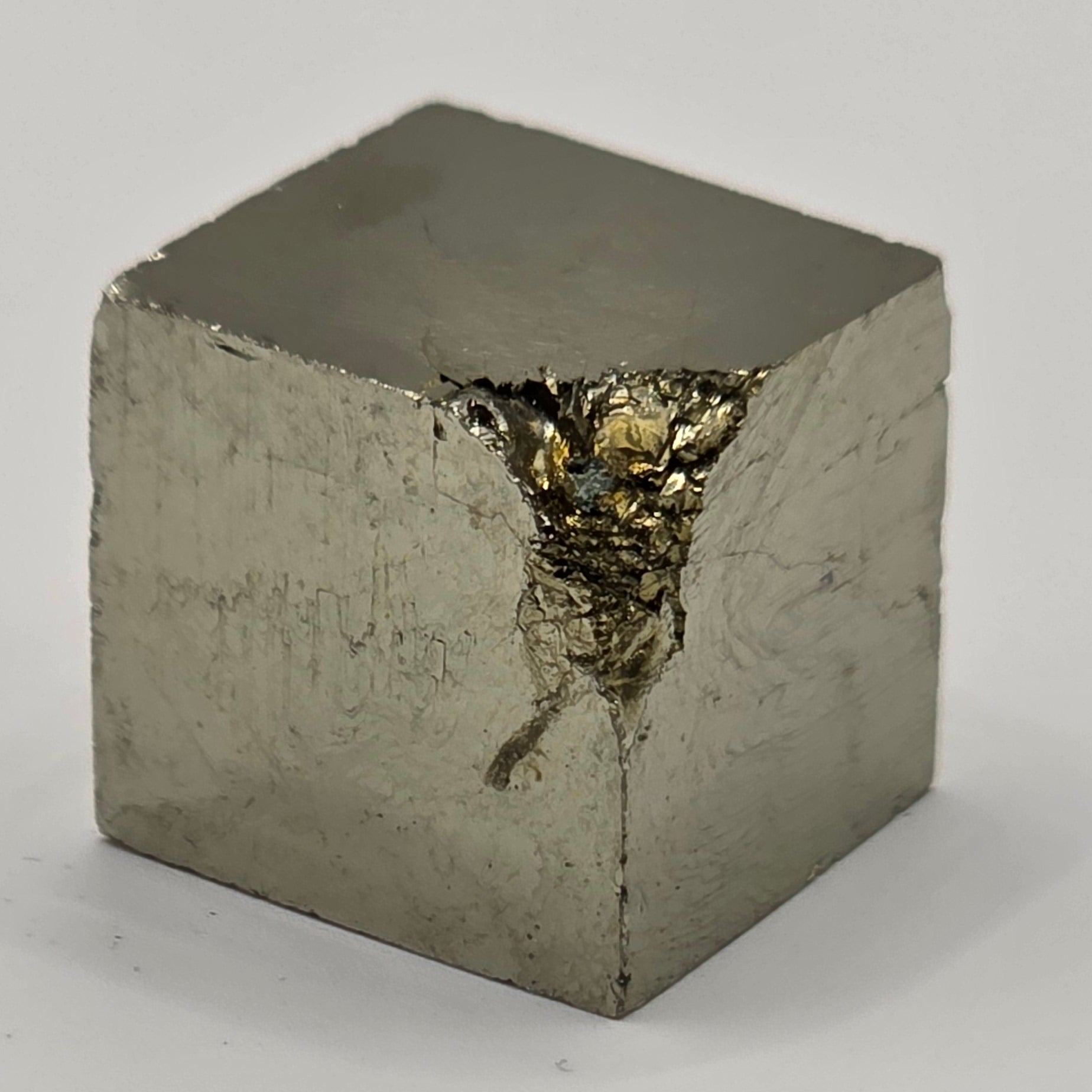 Natural pyrite cube three-quarter view showing multiple cubic faces, metallic sheen, and silver-gold colour – 1cm iron pyrite crystal from Spain