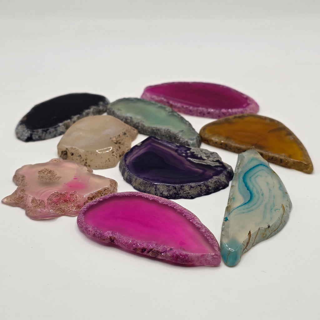 Group of rainbow agate slices showing variety of colours and shapes 