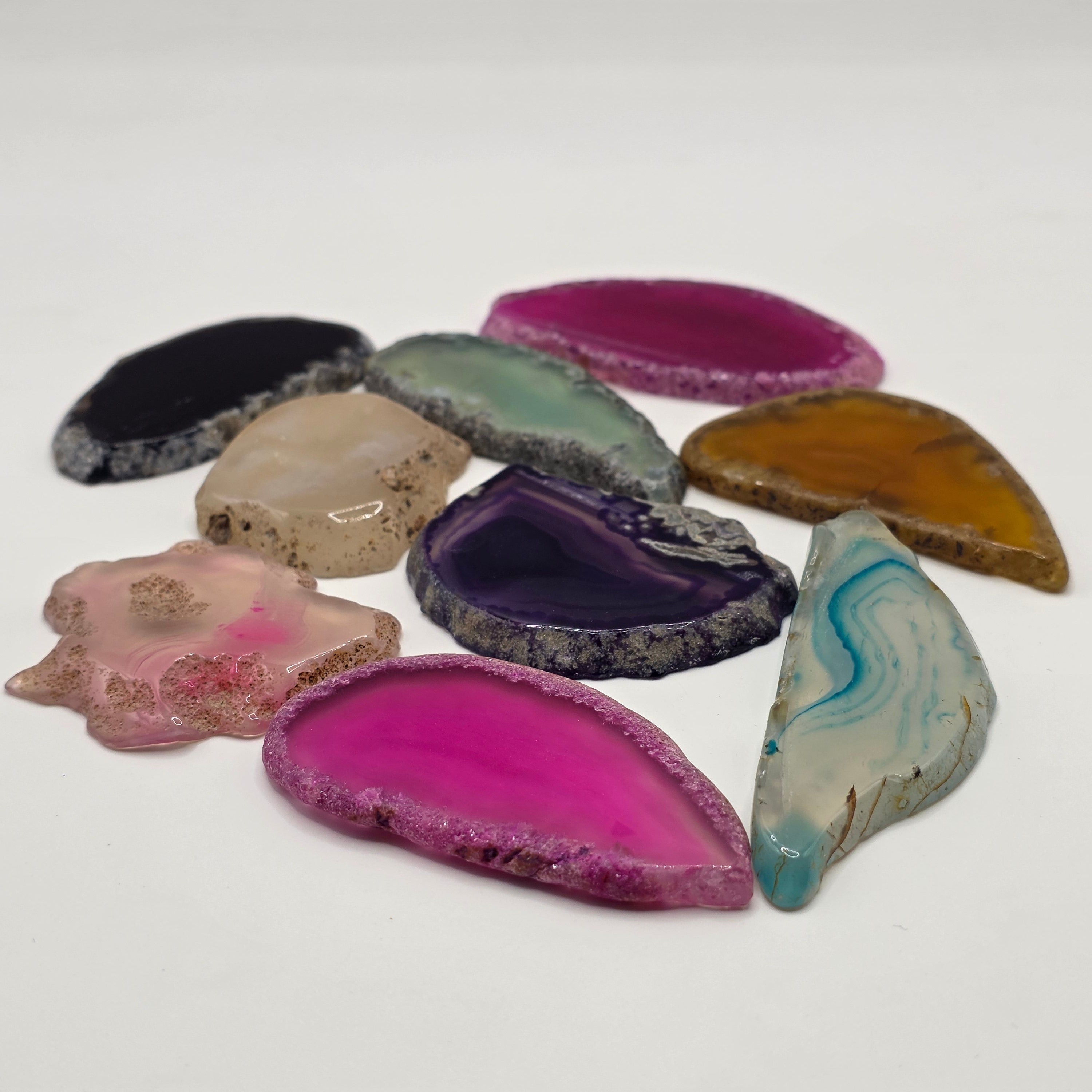 Group of rainbow agate slices showing variety of colours and shapes 