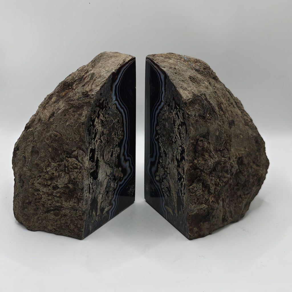 back of the bookends standing upright on a white surface .