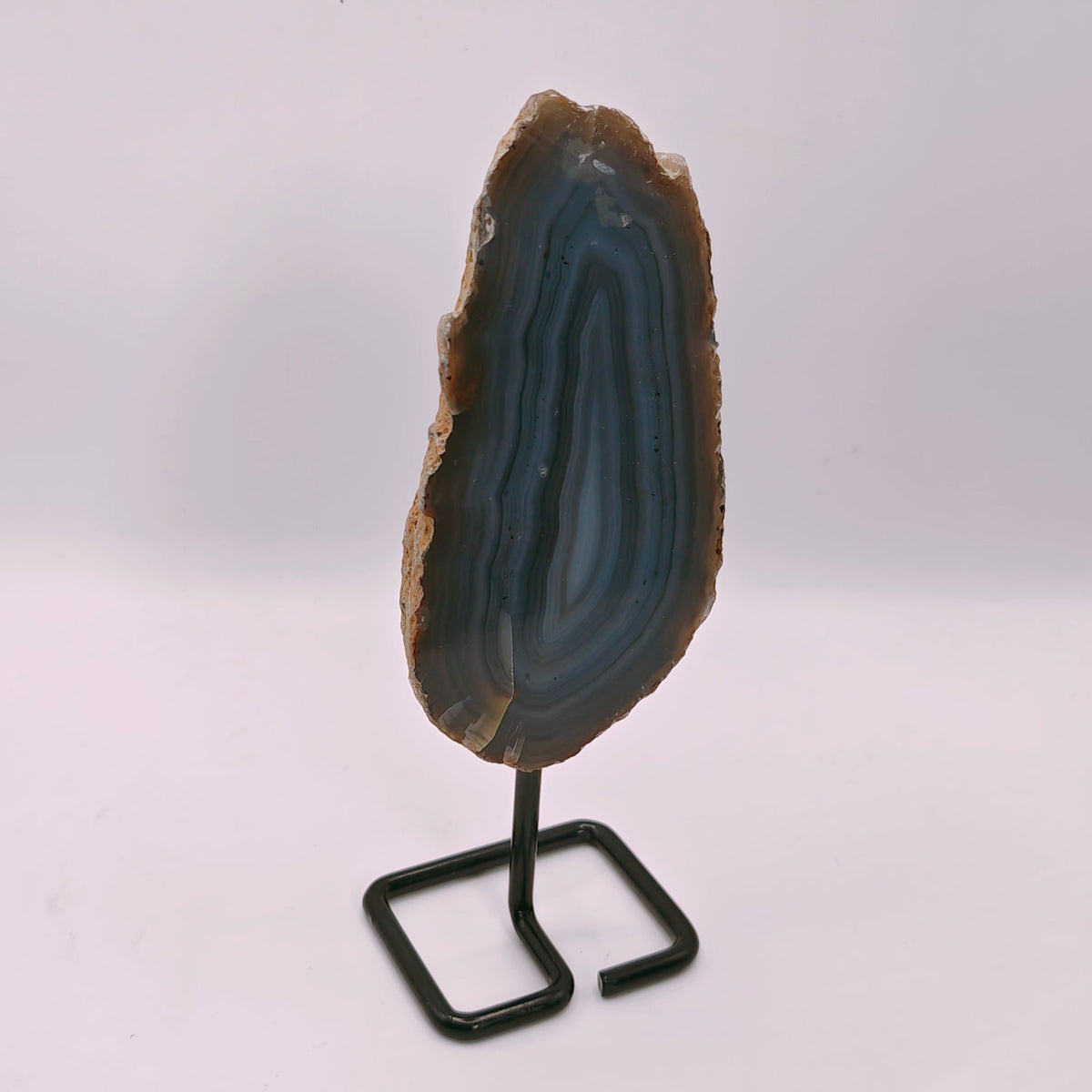 AGATE SLICE ON A BLACK METAL STAND WITH BLUE AND PURPLE BANDING 