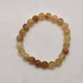 A premium citrine beaded stretch bracelet, photographed on a plain off-white surface.