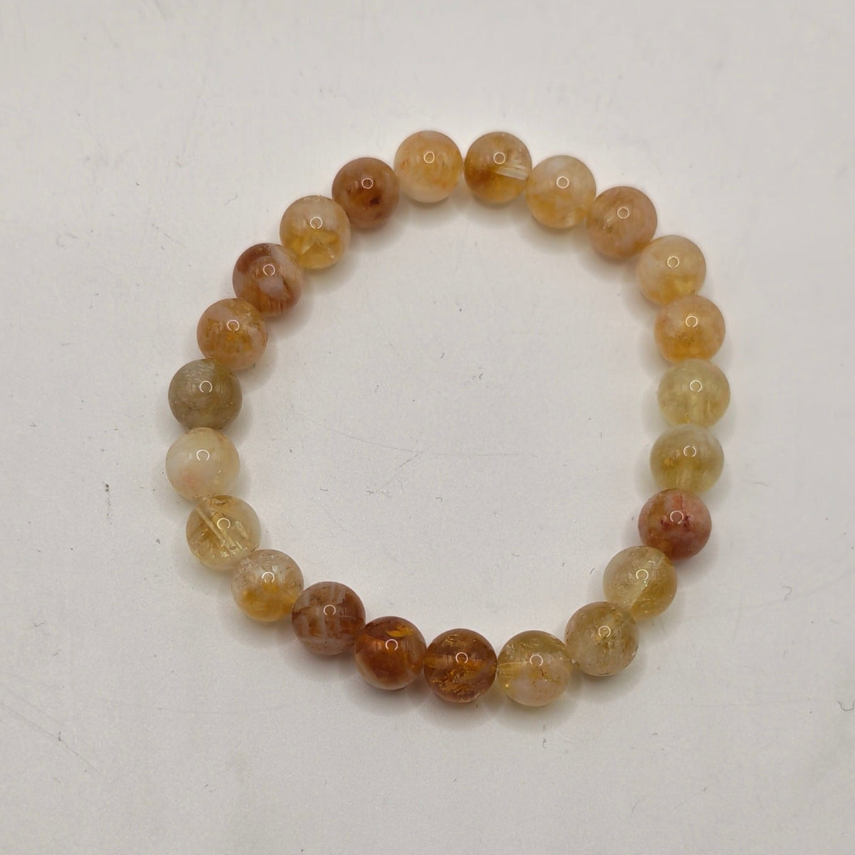 A premium citrine beaded stretch bracelet, photographed on a plain off-white surface.