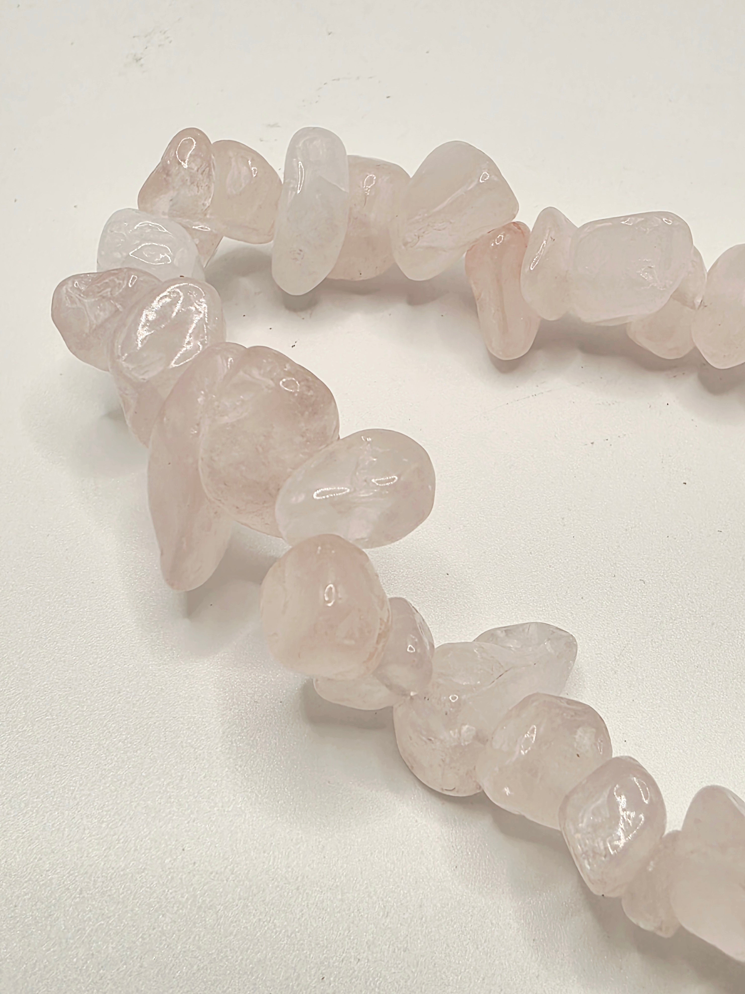 Close up of rose quartz chips showing soft pink colour and natural stone variations