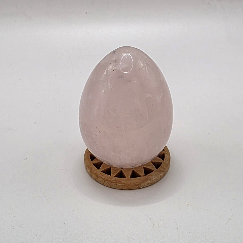 Polished 45mm rose quartz crystal egg on white background