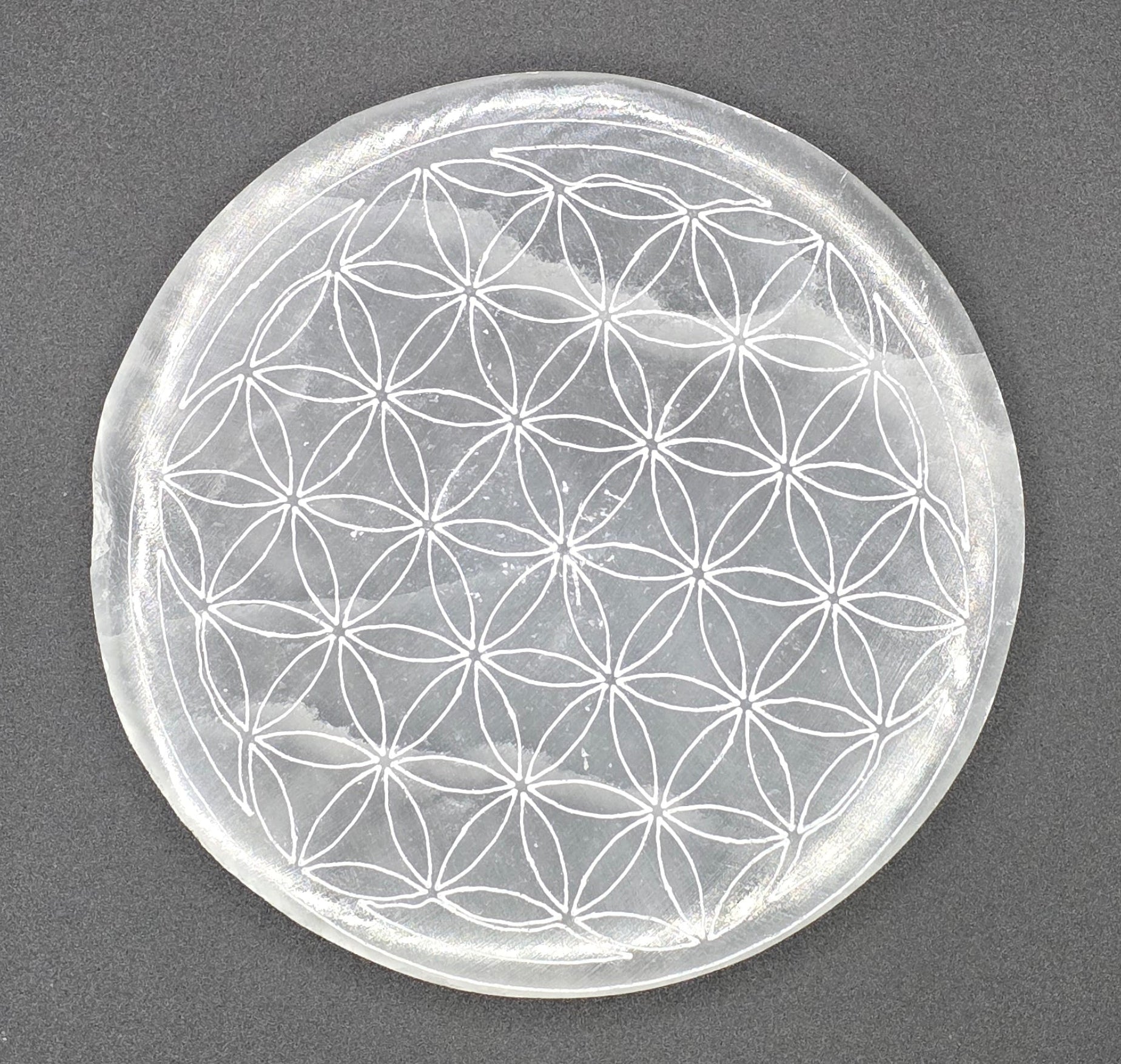 Birdseye View of selenite charging plate showing Flower of Life sacred geometry engraving – natural white selenite
