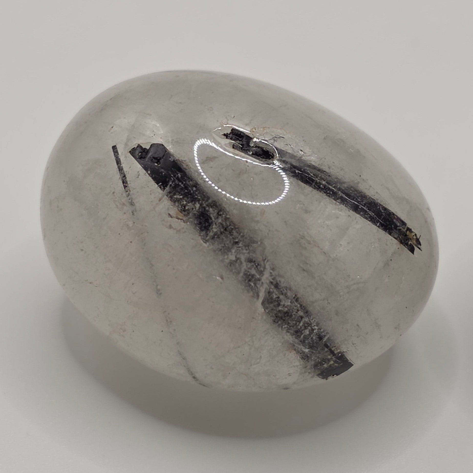 Tourmaline in quartz tumbled stone on white background – clear quartz with black tourmaline needles – 2-3cm polished stone